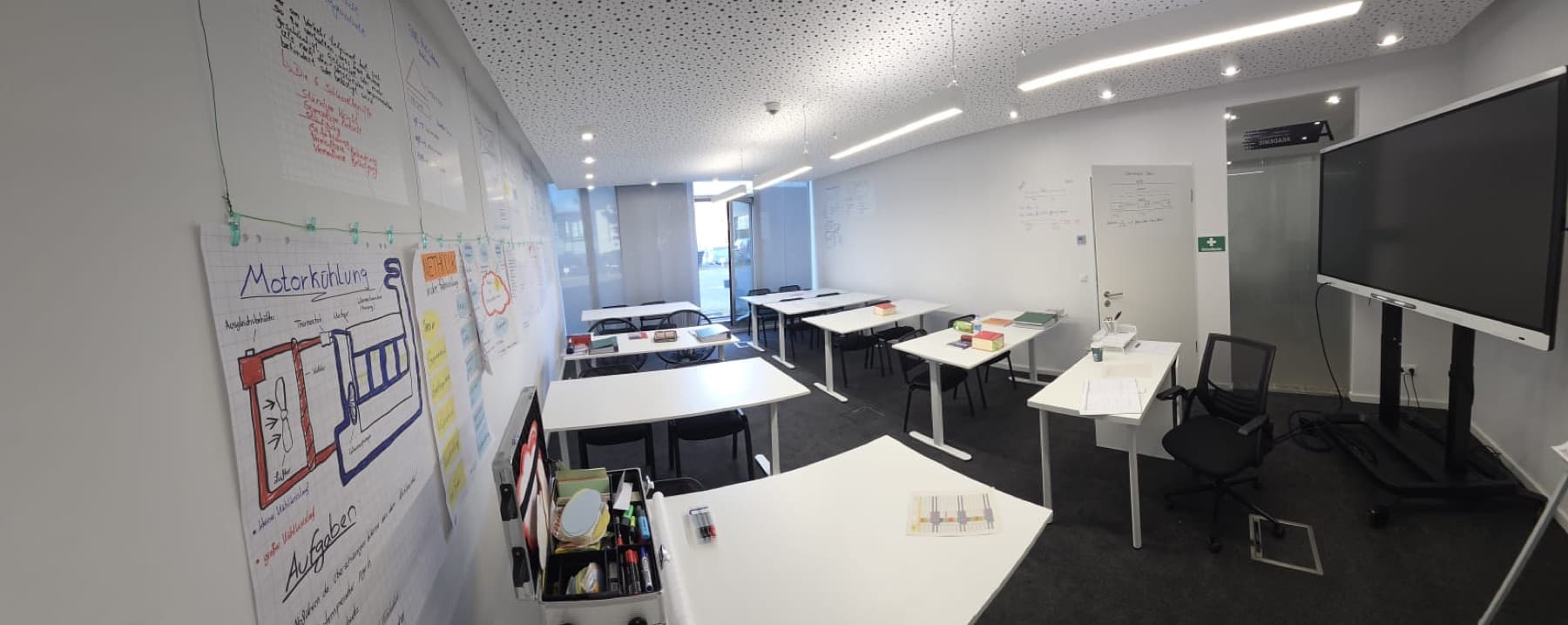 Schulungsraum mit Flipcharts, Lehrplakaten und Smartboard
